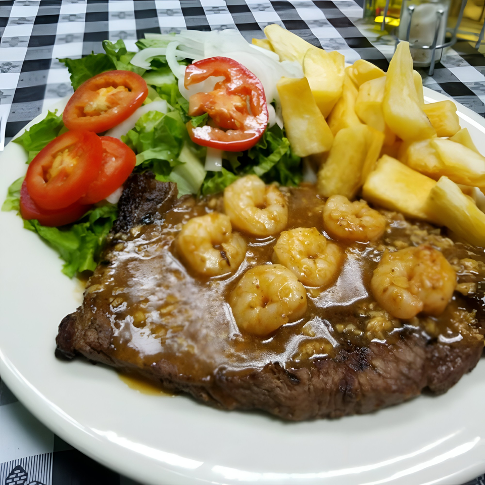 Riva's Bbq Restaurant's steak with shrimp, salad, and fries on a white plate.